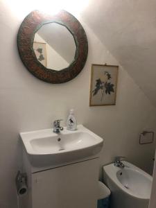 baño con lavabo y espejo en la pared en Suali Case nel Borgo, en Civita Castellana