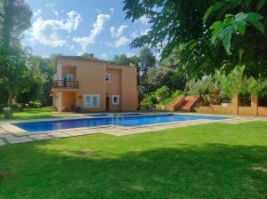 une villa avec une piscine en face d'une maison dans l'établissement El Carrascal, La Sella Golf, à Muntanya la Sella