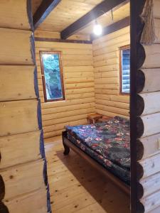 a room with a bed in a log cabin at Cottage Sochi in Ambrolauri