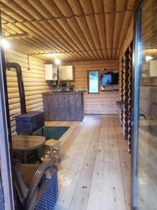 a room with a wooden floor and a table and chairs at Cottage Sochi in Ambrolauri