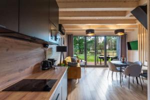 a kitchen and living room with a table and chairs at Po prostu Piękna! Domek nad jeziorem in Stare Jabłonki