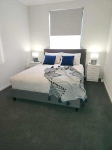 a bedroom with a large bed with blue pillows at RIVER VIEWS in Hindmarsh Island