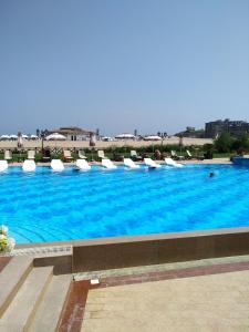 une grande piscine avec des chaises et de l'eau bleue dans l'établissement Oasis Resort & Spa 1 bedroom 5.3.А Stanis, à Lozenets