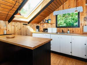 uma cozinha com armários brancos e um tecto de madeira em Holiday home Glesborg LXIII em Glesborg