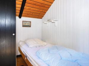 a bed in a room with a wooden ceiling at Holiday home Glesborg LXIII in Glesborg
