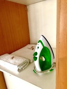 a green and white alarm clock sitting on a shelf next to a bed at Tintswalo Nests in Johannesburg