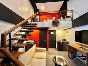 a living room with a staircase and a television at Havitat Boutique Hotel in Manila