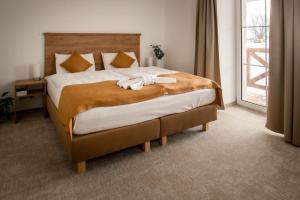 - une chambre avec un grand lit et des serviettes dans l'établissement Penzion Golf Luby, 