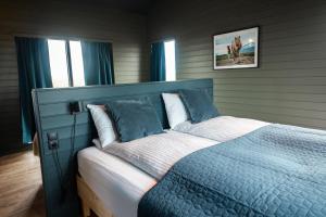 a bedroom with a bed with a blue head board at Sleeping with the Horses in Hvolsvöllur
