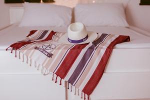 kapelusz i ręcznik na łóżku w obiekcie Terrazza Diomede- Manfredi Homes & Villas w mieście Manfredonia