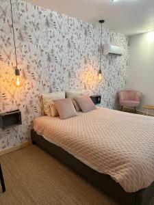 a bedroom with a bed with pink and white wallpaper at Bulles de Nature 