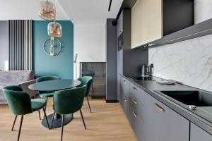 kuchnia ze stołem i zielonymi krzesłami w obiekcie GRANO APARTMENTS Gdańsk Old Town SPA & Wellness - GRANO APARTMENTS Gdańsk Residence SPA & Wellness w Gdańsku +37 zdjęć