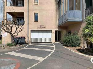 ein Gebäude mit einem Parkplatz mit Garage in der Unterkunft Appartement au bord de l'Hérault in Agde