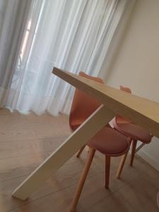 a wooden table and two chairs in front of a window at Txoko Loft Ribera in Tudela