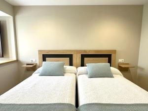 2 camas en una habitación con 2 almohadas en Apartamentos Casa Courego, en Vegadeo