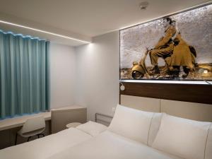 a hotel room with a bed and a painting on the wall at ibis Locarno in Locarno