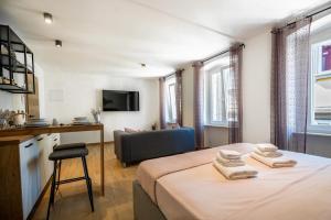 een slaapkamer met een bed, een stoel en een bank bij Apartments Portarata 1 in Pula