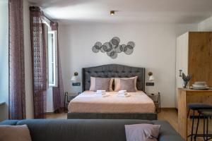 een slaapkamer met een bed en een blauwe bank bij Apartments Portarata 1 in Pula