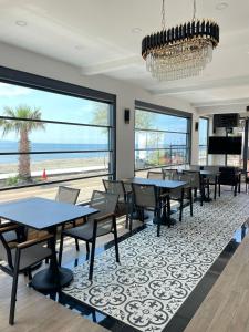 a dining room with tables and chairs and a view of the beach at Palmon Hotel in Erdek