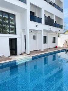 un edificio con piscina frente a él en Palmon Hotel en Erdek