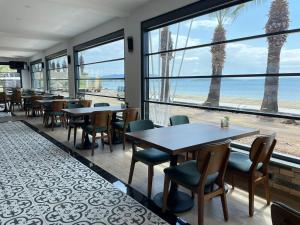 a restaurant with tables and chairs and a view of the beach at Palmon Hotel in Erdek