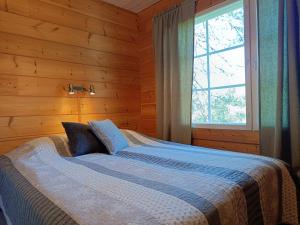 ein Schlafzimmer mit einem Bett in einem Holzzimmer in der Unterkunft Poronpolku in Syöte