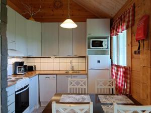 una cocina con armarios blancos y electrodomésticos blancos en Poronpolku, en Syöte