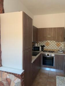 a kitchen with wooden cabinets and a stove top oven at Casa Balilla 2 in La Maddalena +8 photos