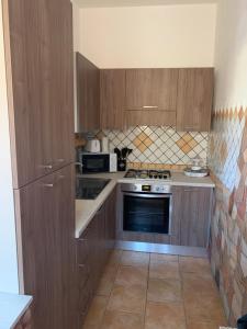 a kitchen with wooden cabinets and a stove top oven at Casa Balilla 2 in La Maddalena