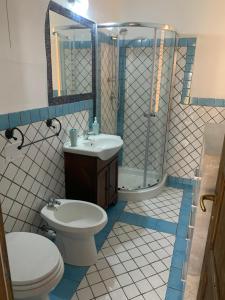 a bathroom with a toilet and a sink and a shower at Casa Balilla 2 in La Maddalena