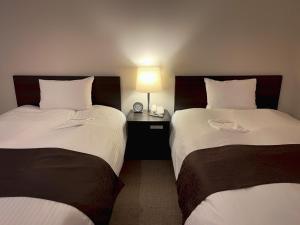 Postel nebo postele na pokoji v ubytování Shinjuku Sun Park Hotel