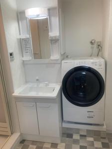 a washing machine and a sink in a bathroom at COPO YONEGAHAMA l 米が浜通 in Kusugaurachō