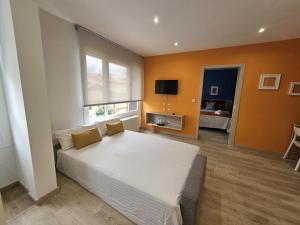 sypialnia z dużym białym łóżkiem i kanapą w obiekcie Inicia AVIO Apartamentos w Santiago de Compostela