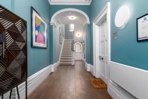 a hallway with blue walls and a staircase at Charlotte Rise in Bristol