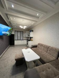 Una sala de estar con un sofá y un televisor. en Central Apartment, en Samarkand
