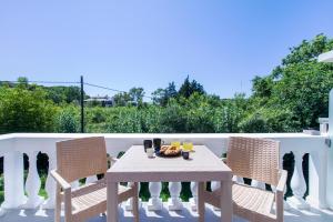 a table and chairs on a patio with a view at Anais Luxury Living Grey & Pink by CorfuEscapes in Marathias