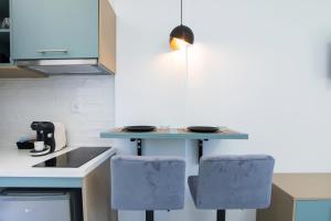 a kitchen with two blue chairs and a counter at Anais Luxury Living Grey & Pink by CorfuEscapes in Marathias +7 photos
