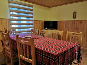 a dining room with a table and chairs and a television at Комплекс Петлето in Smolyan