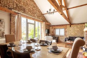 a dining room with a wooden table and chairs at The Cart Lodge - relaxing rural spa break in Pentney