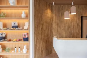 a bathroom with a white toilet and a wooden wall at H&ocirc;tel Ibaia in Hendaye