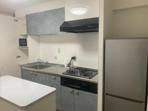 una cucina con fornelli e frigorifero di COPO YONEGAHAMA l 米が浜通 a Kusugaurachō