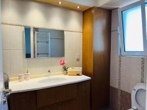 y baño con lavabo y espejo. en Rare Seaview Penthouse in Paleo Faliro en Athens