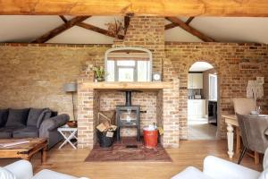a living room with a brick wall and a fireplace at The Cart Lodge - relaxing rural spa break in Pentney