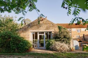 a brick house with a door and a patio at The Cart Lodge - relaxing rural spa break in Pentney