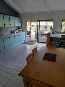 uma cozinha com mesa e cadeiras e uma sala de jantar em Muri Lagoon Lodge em Titikaweka