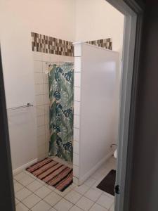 W łazience znajduje się prysznic z zasłoną prysznicową. w obiekcie Muri Lagoon Lodge w mieście Titikaweka