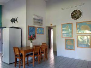 a dining room with a table and chairs and a refrigerator at Muri Lagoon Lodge in Titikaweka