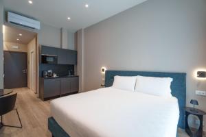 a hotel room with a large bed and a kitchen at Vi Suites in Viareggio