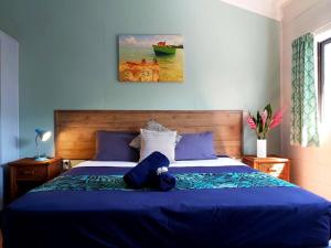 uma cama azul com um urso de peluche deitado nela em Muri Lagoon Lodge em Titikaweka