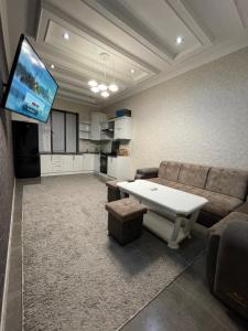 Una sala de estar con un sofá y un televisor. en Central Apartment, en Samarkand
